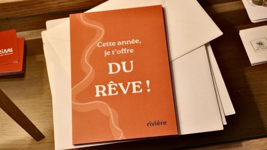 Carte 'Cette année, je t'offre du rêve !' posée sur des enveloppes